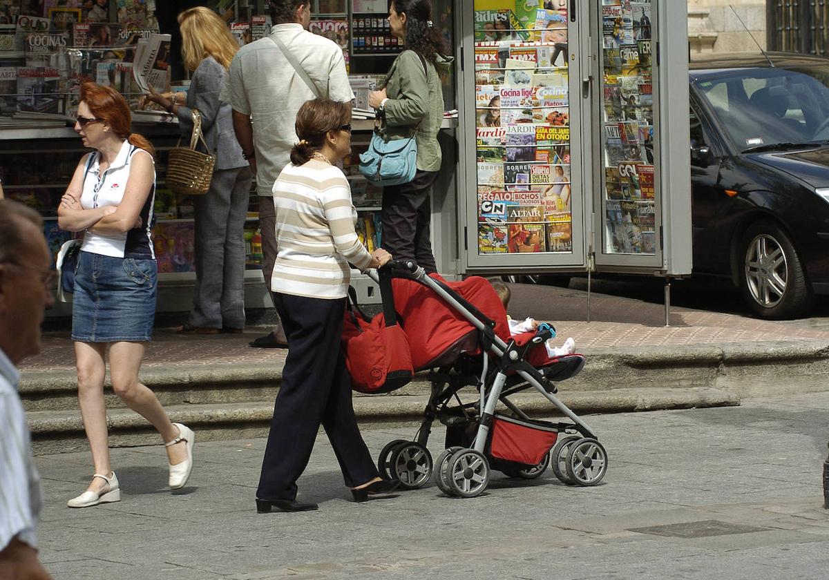 Una salmantina pasea con un carrito de bebé por el centro de la capital.