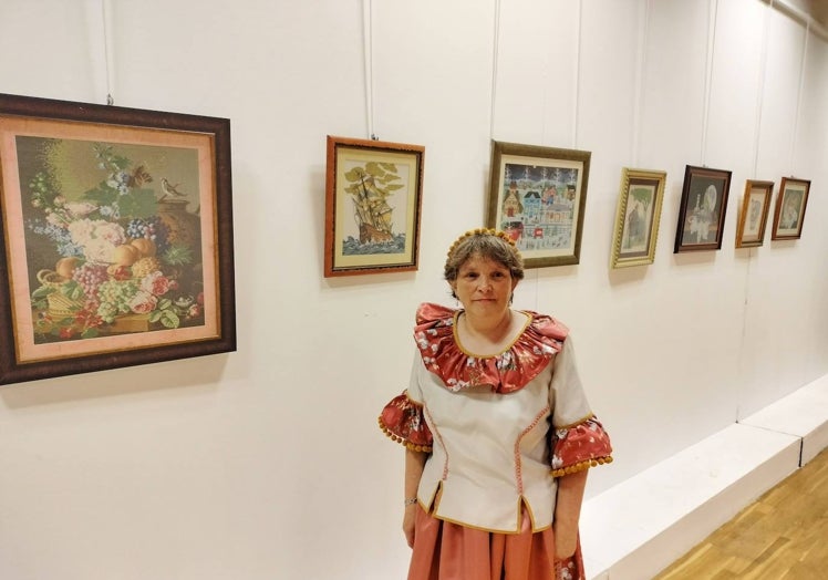 Imagen principal - Trini García Fonseca abrió, ataviada de goyesca, su exposición de cuadros de punto de cruz.