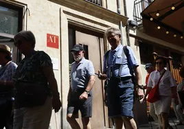 Turistas pasan frente a la entrada de un edificio con apartamentos turísticos en Salamanca.