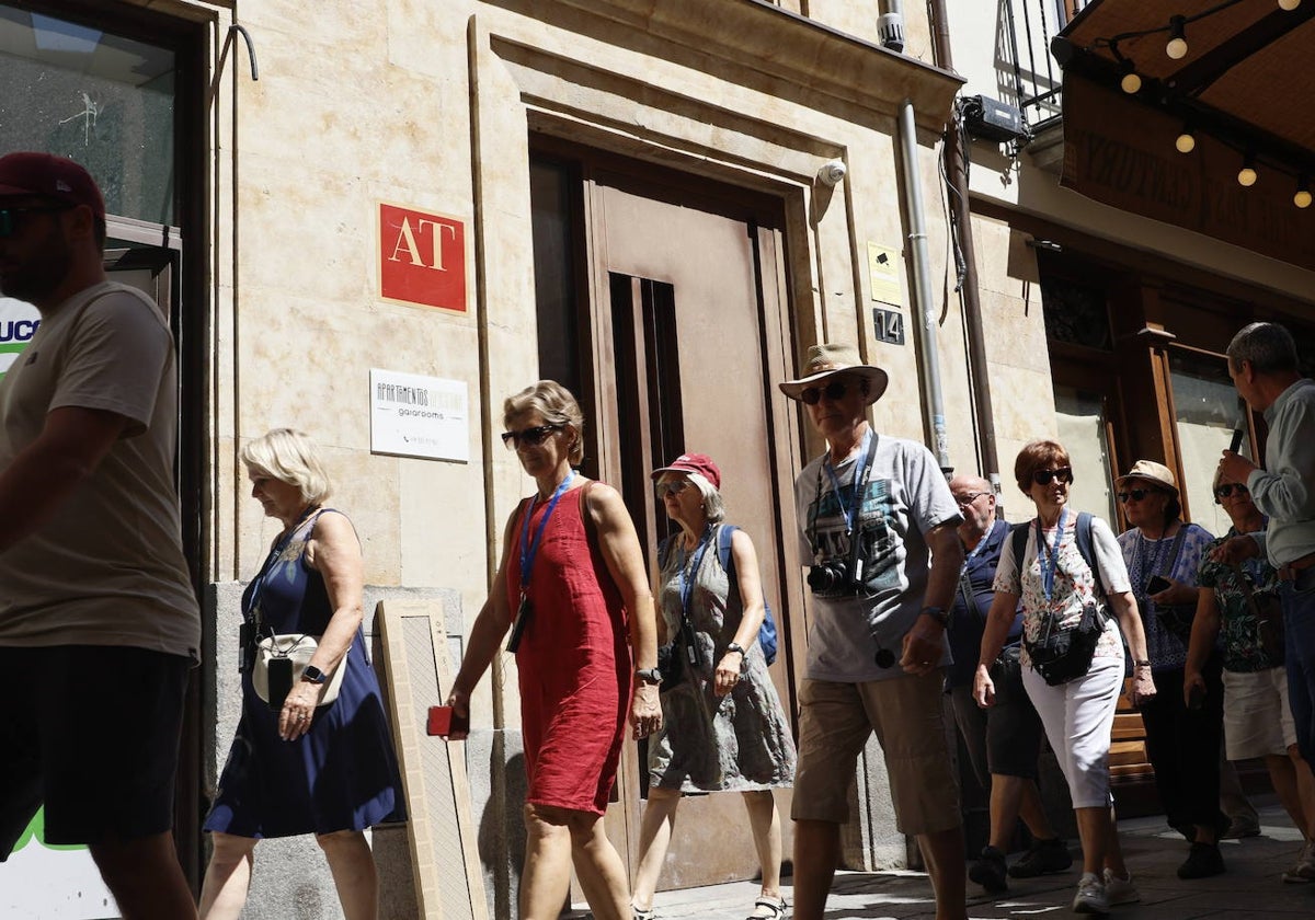 Turistas pasan junto a un alojamiento turístico de Salamanca.