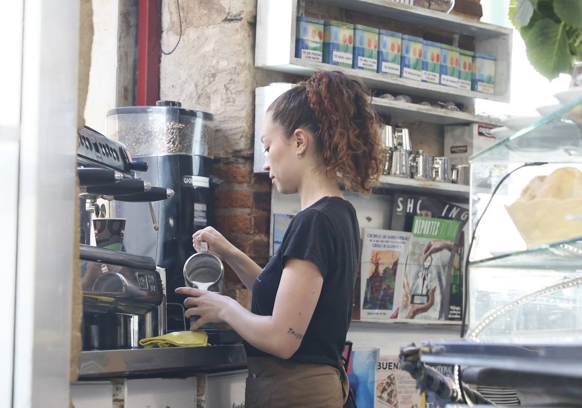 Una camarera sirviendo un café.