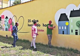 Jesús, Álvaro y Alfonso junto al mural recién realizado por los 25 años del centro 'Padre Damián'.