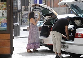 Una mujer se hidrata en la plaza del mercado de Salamanca.