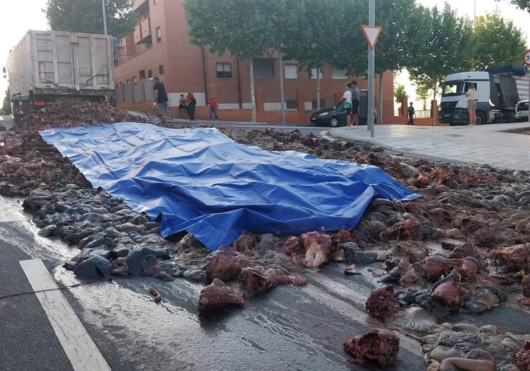 Imagen principal - La apertura de la puerta de un camión deja trozos de carne en la calle Astorga