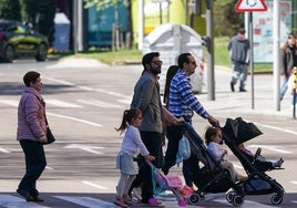 Imagen de una familia paseando por Salamanca con un carrito de bebé.