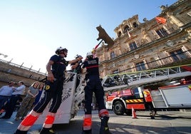 Los Bomberos colocan La Mariseca en lo alto del Ayuntamiento de Salamanca.