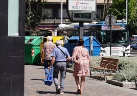 Salmantinos paseando frente a un termómetro que marca 37 grados.