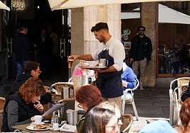 Un camarero sirve a un salmantino una cerveza en una terraza del centro de Salamanca.