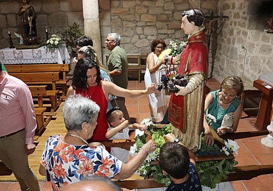 Los vecinos degustan las uvas que llevaba el santo tras regresar a la iglesia parroquial