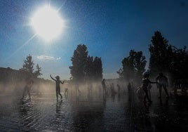 Varios niños se refrescan en una fuente durante la tercera ola de calor en Madrid.