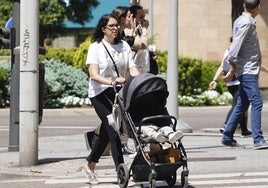 Imagen de una salmantina con un carrito de bebé.