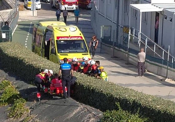 Bomberos y personal médico atienden al obrero tras caerse por un desnivel.