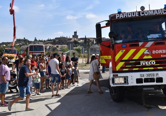 Vecinos de Ledesma esperando a montar en los vehículos de los bomberos.