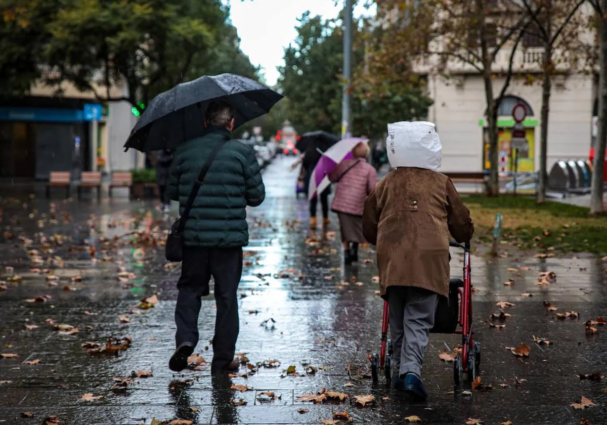 Dos personas se protegen de la lluvia.