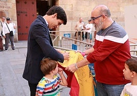Pablo Aguado firmando un autógrafo en un pequeño capotillo para recuerdo de un par de jovencísimos aficionados.