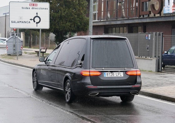 Un coche fúnebre por el barrio de Tejares.