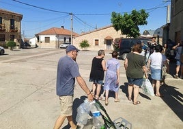 Vecinos de la localidad de Rollán yendo a recoger agua potable a los depósitos portátiles.