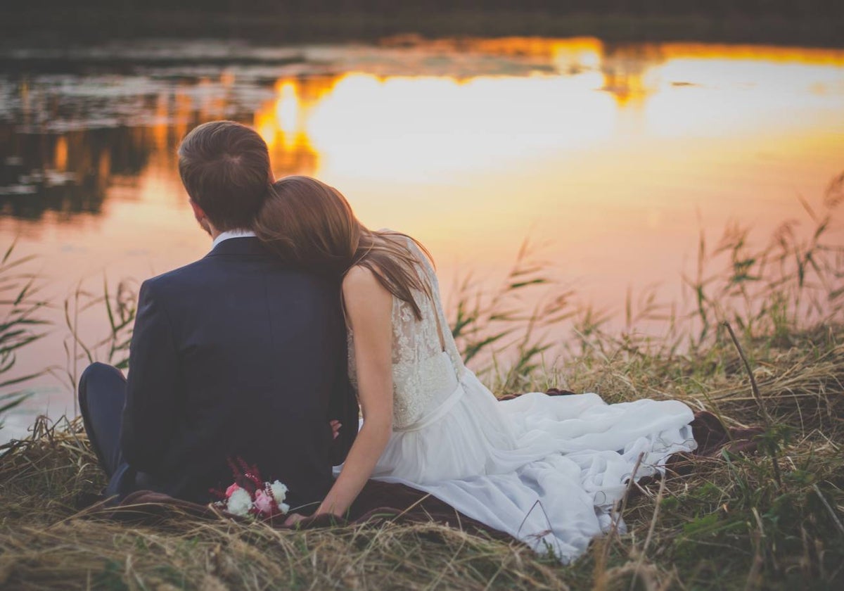 Una pareja de recién casados a la orilla del río.