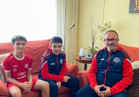 Miguel (izquierda), Adrián (centro) y Justo (derecha) posan en el salón de su casa.