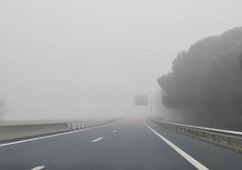 Imagen de una carretera de Castilla y León con poca visibilidad debido a la niebla.