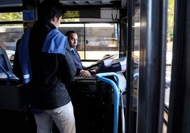 Un joven paga su billete en un autobús urbano.