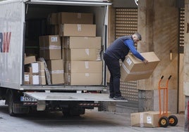 Un trabajador trasladando cajas desde un camión.