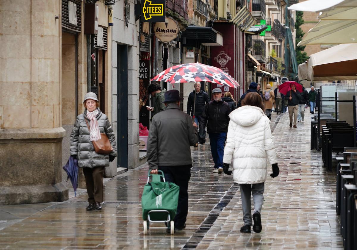 Varios salmantinos, caminando por el centro de Salamanca en la mañana de este martes.