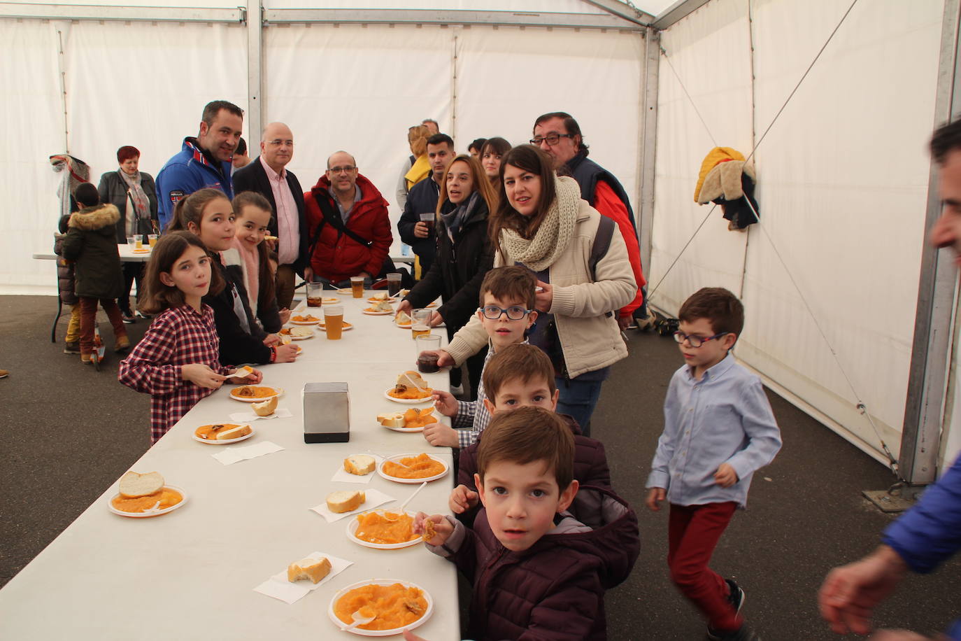 Un grupo de vecinos, durante la degustación de patatas meneás en la carpa instalada en el camino de Moriscos.