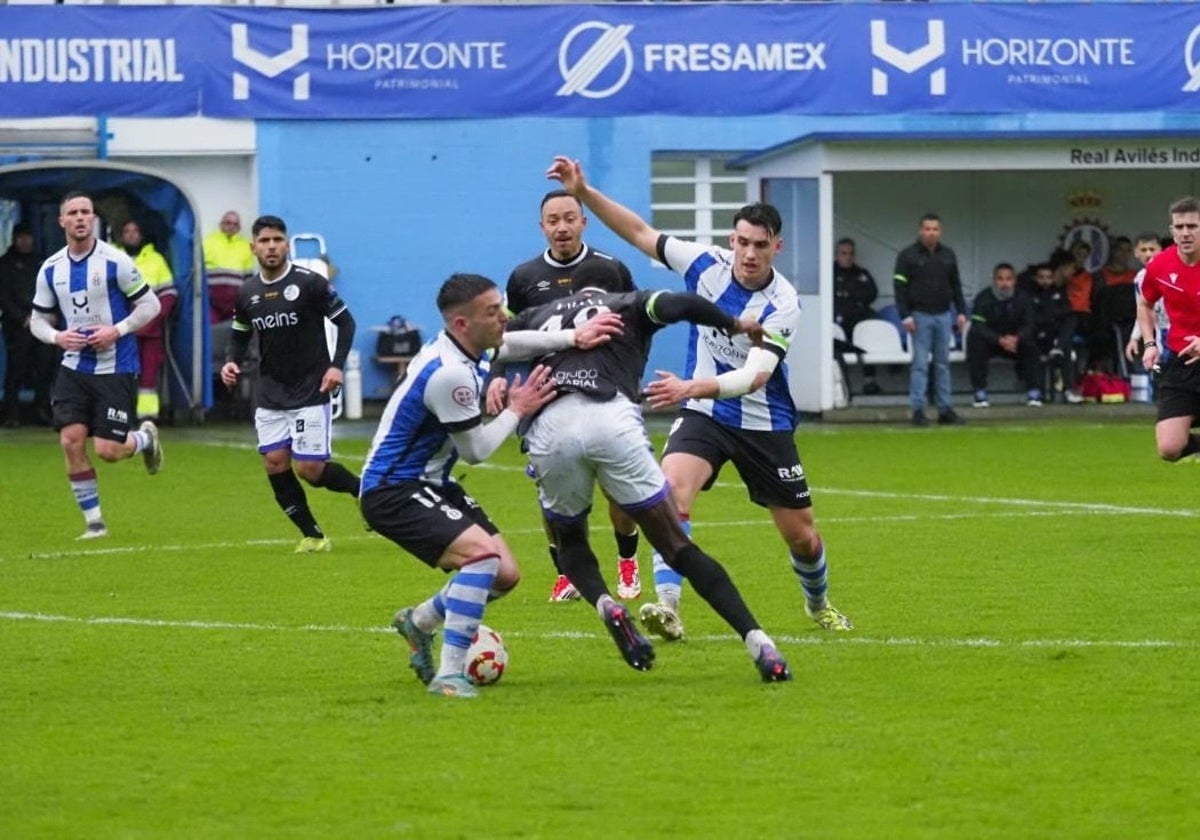 Emaná, entre dos jugadores del equipo asturiano.