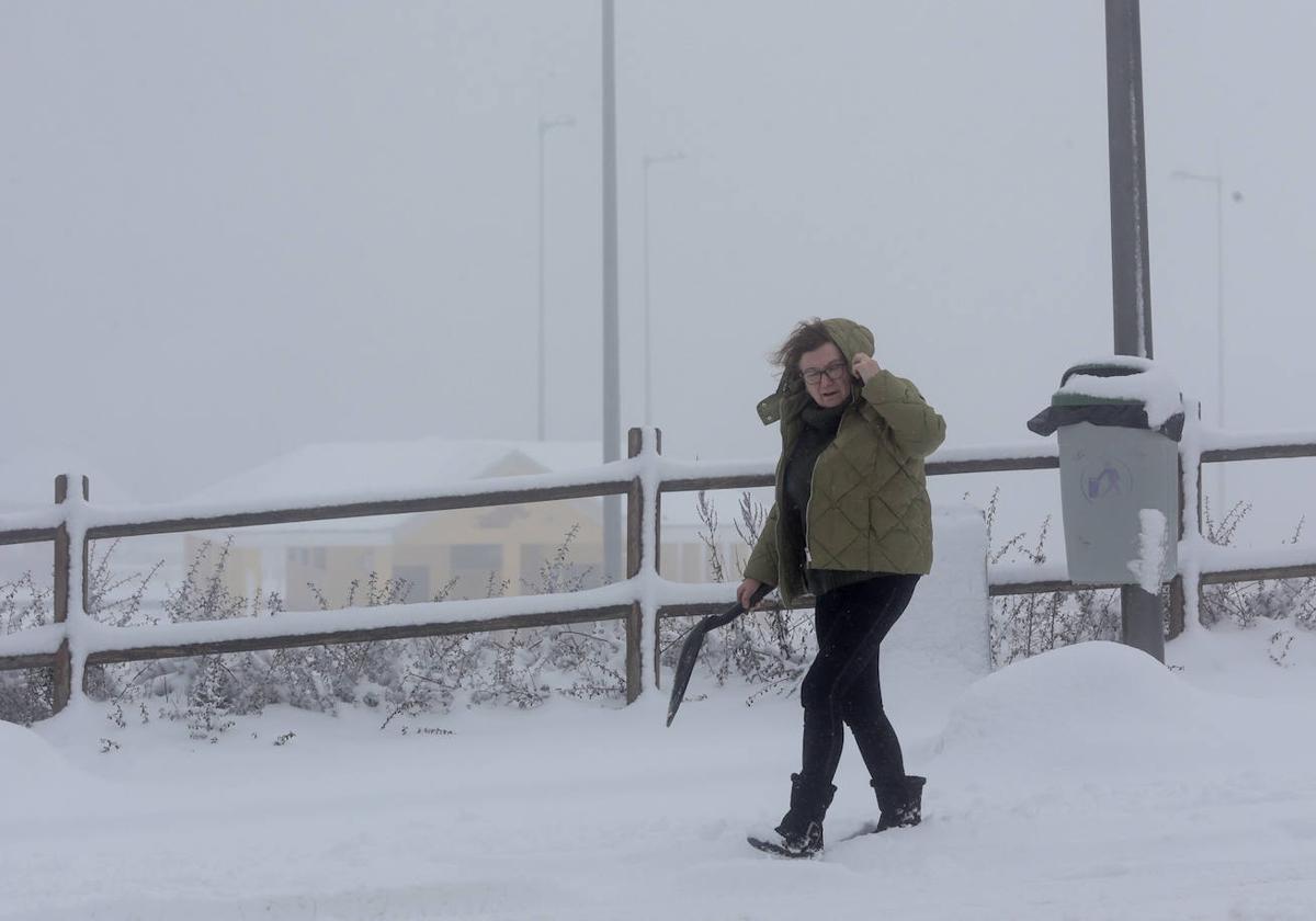 Una mujer camina en una calle repleta de nieve en una imagen de archivo.