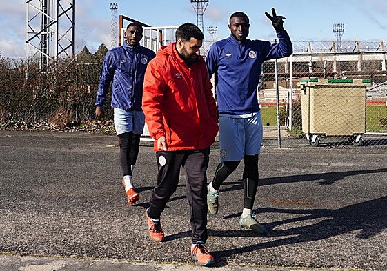 Souley Gassama, haciendo el símbolo de la victoria, llegando a entrar junto al fisio del club Manuel Vicente y Emaná.