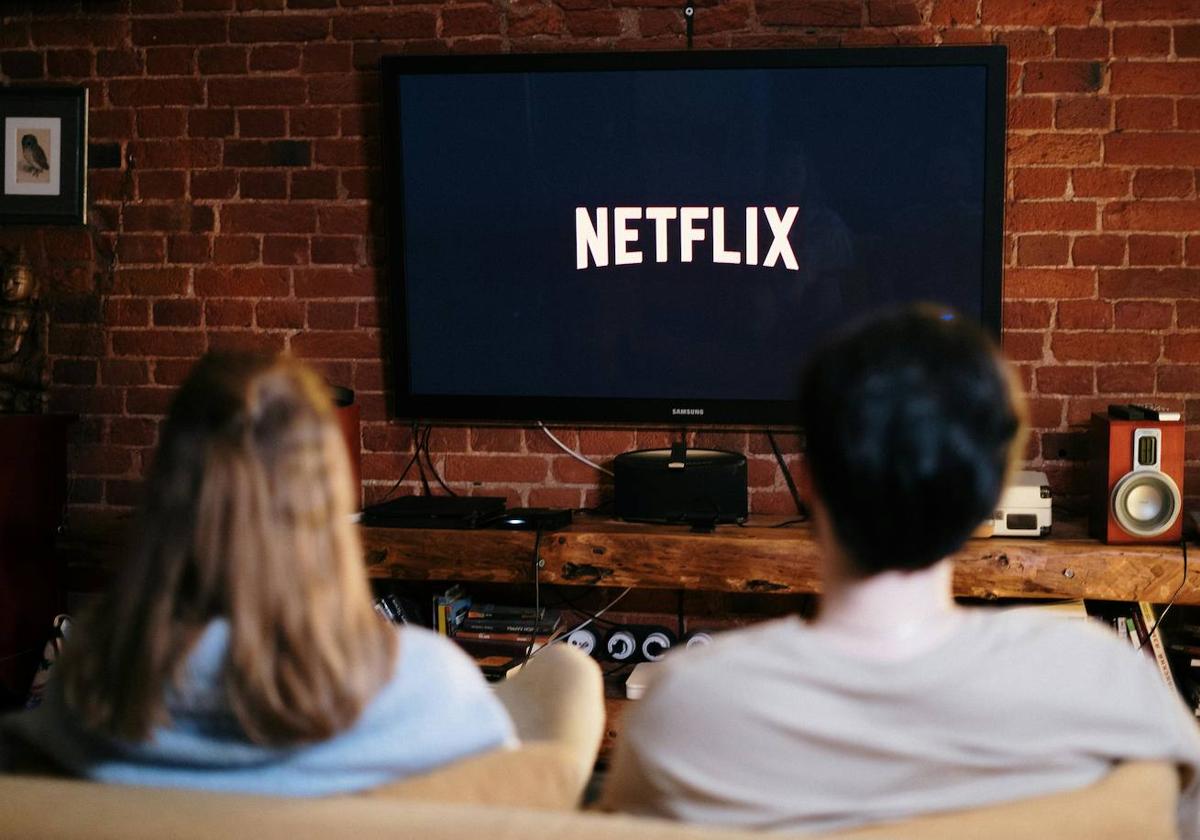 Dos personas a punto de ver un contenido de Netflix en la televisión.