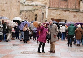 Turistas miran preocupados al cielo en un día de lluvia en Salamanca.