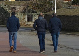 Tres hombres caminando por una de las calles de Gejuelo del Barro.