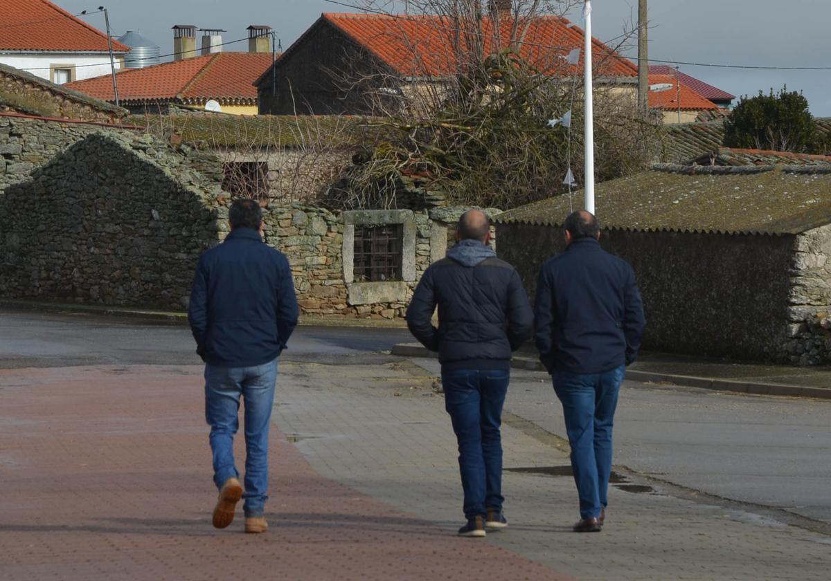 Tres hombres caminando por una de las calles de Gejuelo del Barro.