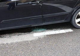 Restos de cristales de uno de los vehículos afectados en la calle Astorga.
