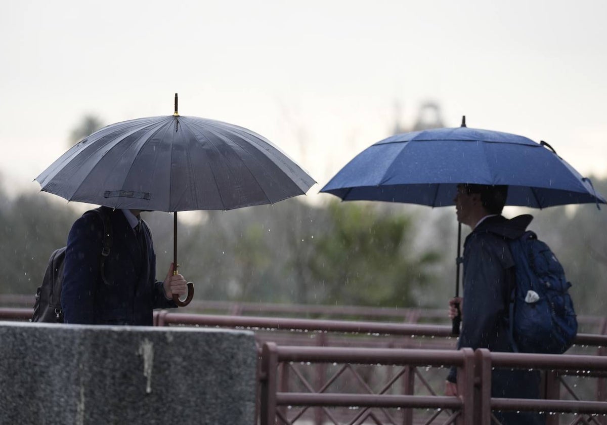 Dos personas se protegen de la lluvia con un paraguas