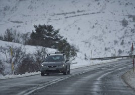 Coche circulando por una carretera nevada