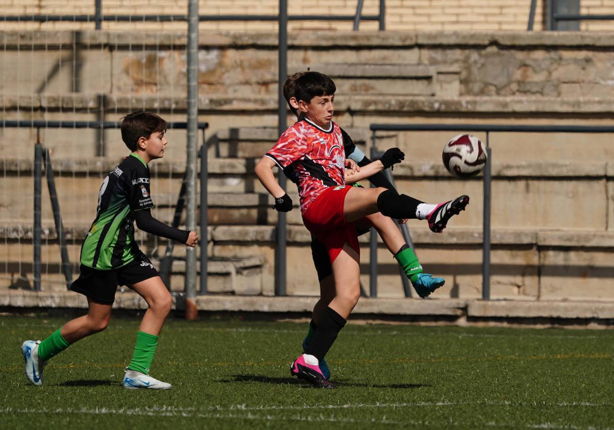 Jugadores de ambos conjuntos pugnan por hacerse con el control del esférico durante el encuentro infantil.