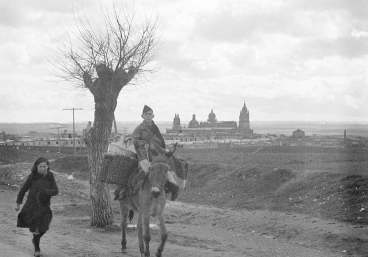 Dos jóvenes y su burro con el perfil de Salamanca al fondo en 1937.