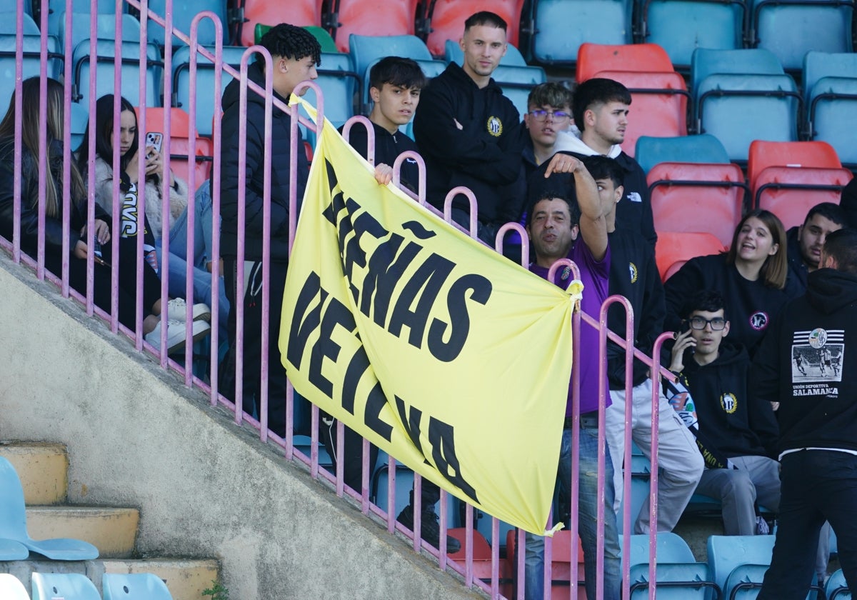 Aficionados del Salamanca UDS junto a una pancarta de 'Dueñas, vete ya'.