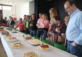 Un grupo de vecinos de Doñinos observando las tartas presentadas al concurso de adultos