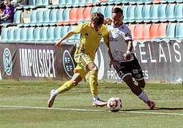 Juancho intenta hacerse con el esférico ante un jugador del Langreo.