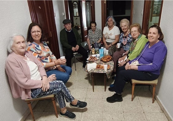 Vecinos de Garrido celebran el feliz desenlace en el rellano con una merienda compartida.