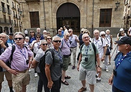 Un grupo de turistas observa los vítores en uno de los laterales de la Clerecía.