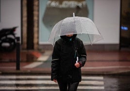 Una persona se protege de la lluvia con paraguas.