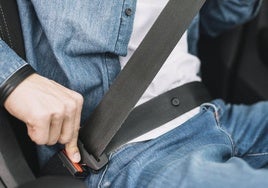 Una persona se pone el cinturón de seguridad para empezar a conducir.