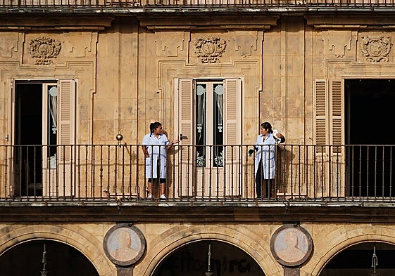 Dos trabajadoras de la limpieza en un balcón de la Plaza.