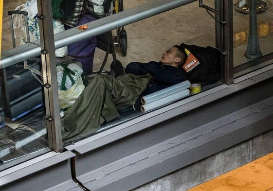 hombre duerme en la T4 del Aeropuerto Adolfo Suárez-Madrid Barajas.