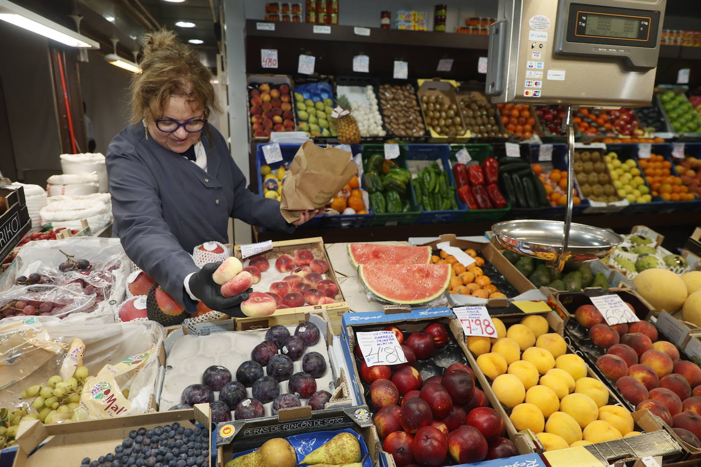 Una frutera coge varias paraguayas.